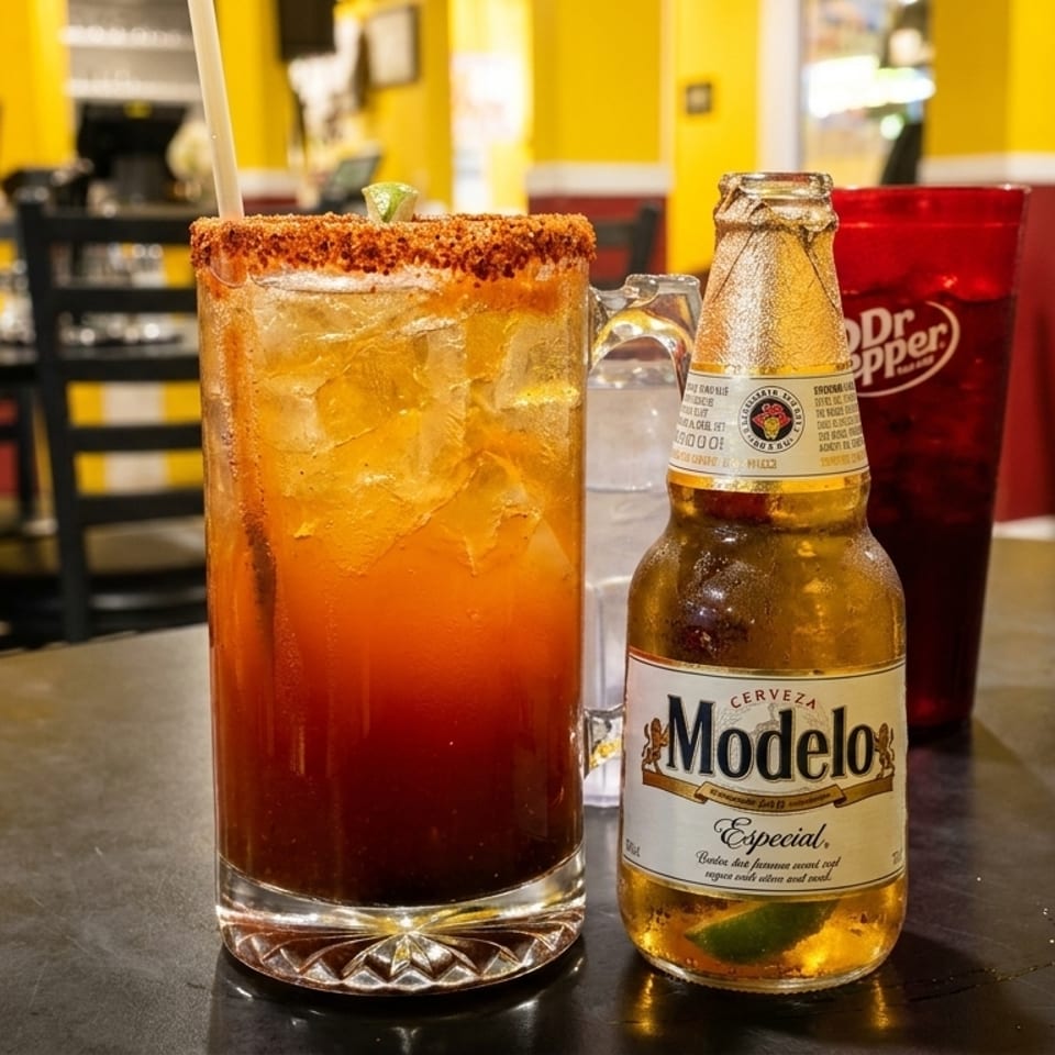 A Modelo Especial beer, a michelada, and a Dr. Pepper on a table in a vibrant restaurant.